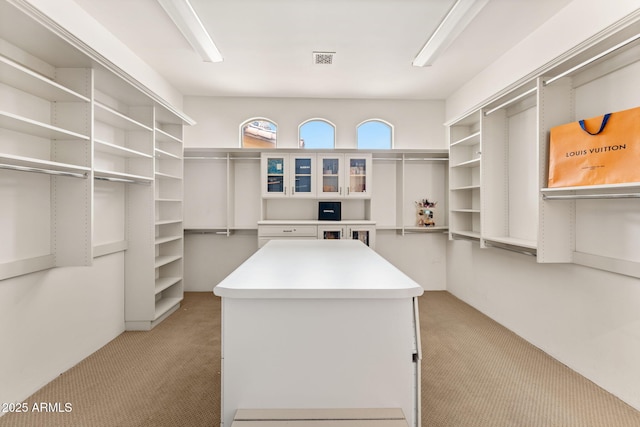 walk in closet featuring light carpet and visible vents