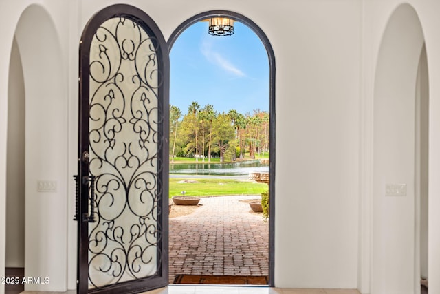 entryway featuring a water view and an inviting chandelier
