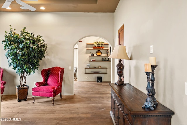 living area featuring arched walkways, ceiling fan, recessed lighting, and wood finished floors
