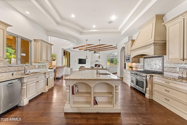 kitchen featuring appliances with stainless steel finishes, a tray ceiling, and cream cabinetry