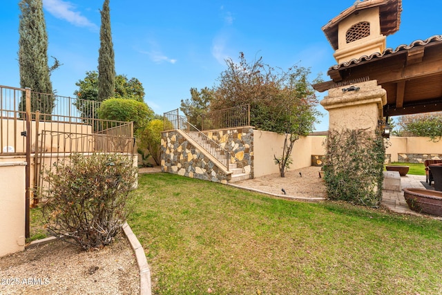 view of yard featuring fence and stairway