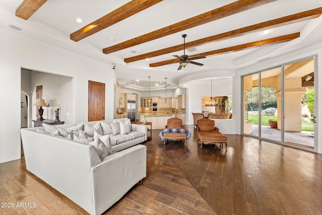 living area featuring arched walkways, beam ceiling, visible vents, and dark wood finished floors