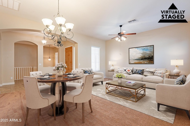 carpeted dining room with ceiling fan with notable chandelier