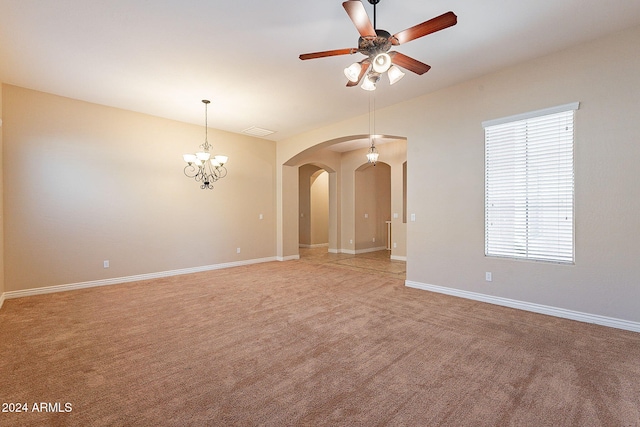 unfurnished room featuring ceiling fan with notable chandelier and carpet floors