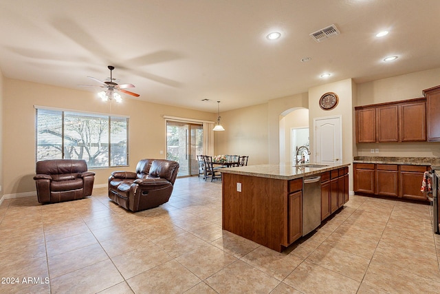 kitchen with ceiling fan, sink, stainless steel dishwasher, decorative light fixtures, and a kitchen island with sink