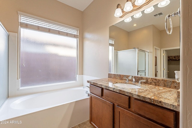 bathroom featuring plus walk in shower, vanity, and tile patterned flooring