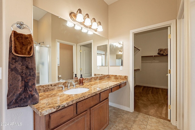 bathroom with tile patterned flooring, vanity, a shower with shower door, and toilet