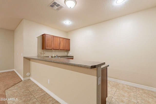 kitchen with kitchen peninsula and light tile patterned flooring