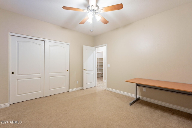 unfurnished bedroom featuring light colored carpet, a closet, and ceiling fan