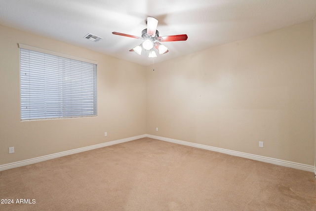 unfurnished room with light colored carpet and ceiling fan