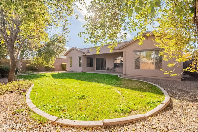 back of property featuring a yard and a patio