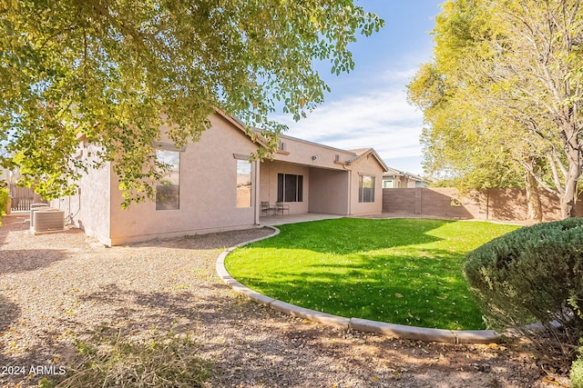 rear view of house featuring a lawn, central air condition unit, and a patio