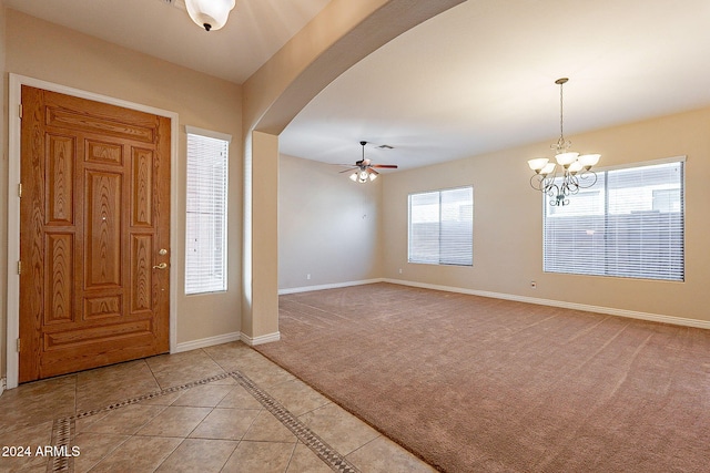 foyer entrance featuring light tile patterned flooring and ceiling fan with notable chandelier