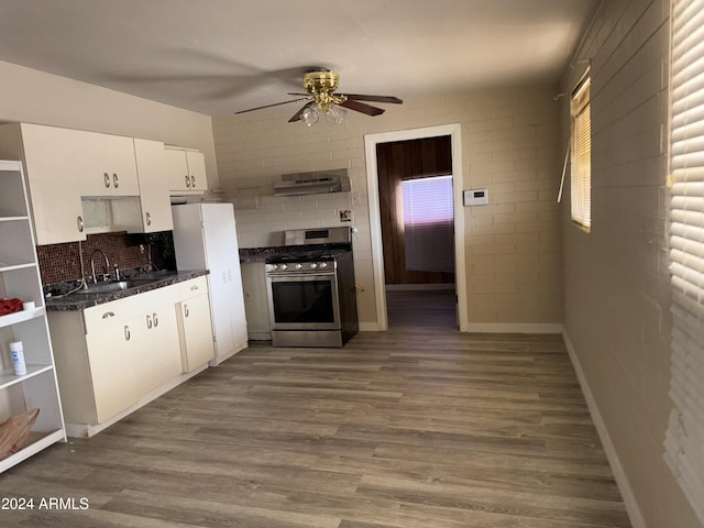 kitchen featuring brick wall, ceiling fan, sink, white cabinets, and stainless steel range with gas cooktop