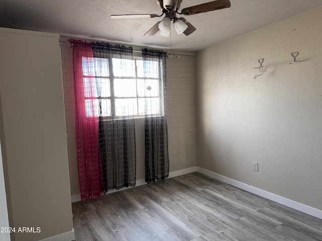 spare room with ceiling fan, wood-type flooring, and a textured ceiling