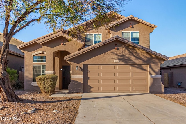 mediterranean / spanish-style house featuring a garage, driveway, a tiled roof, and stucco siding