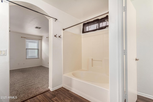 full bath featuring bathtub / shower combination, visible vents, baseboards, and wood finished floors