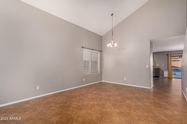 spare room featuring a chandelier, high vaulted ceiling, and baseboards