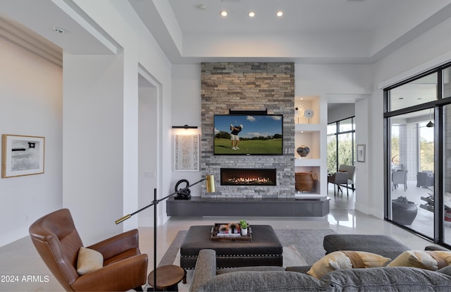 tiled living room with recessed lighting, baseboards, and a stone fireplace