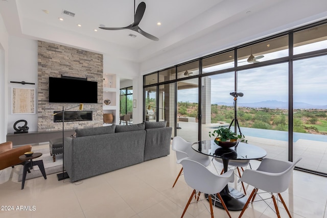 dining space with a ceiling fan, tile patterned floors, a fireplace, and visible vents