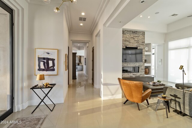 living room with light tile patterned flooring, visible vents, and a stone fireplace