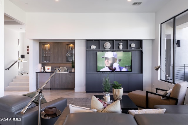 living area with visible vents, wood finished floors, recessed lighting, stairway, and wet bar