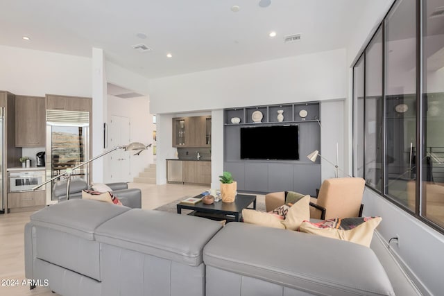 living room featuring light wood-style flooring, recessed lighting, and visible vents