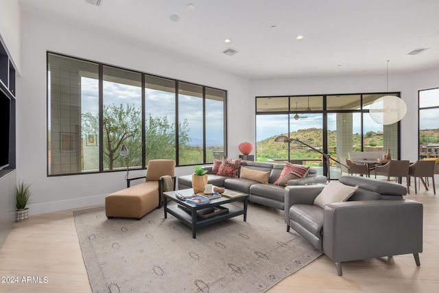 living area with visible vents, recessed lighting, light wood-type flooring, and baseboards