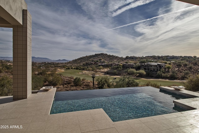 view of swimming pool with a mountain view