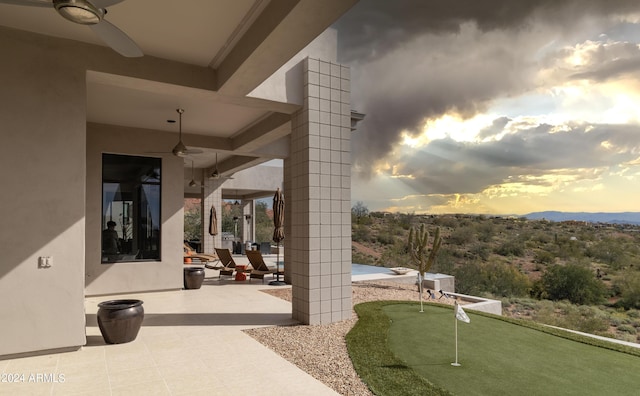 view of patio / terrace with a ceiling fan and a mountain view