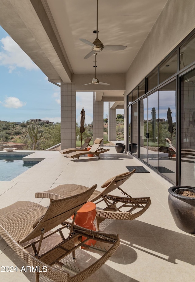 view of patio / terrace featuring an outdoor pool and a ceiling fan