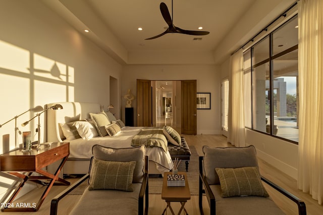 bedroom with a high ceiling, recessed lighting, baseboards, and light wood finished floors