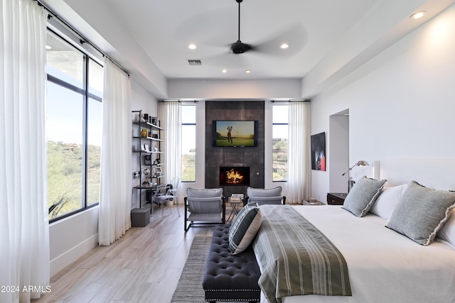 bedroom featuring baseboards, visible vents, recessed lighting, light wood-type flooring, and a large fireplace