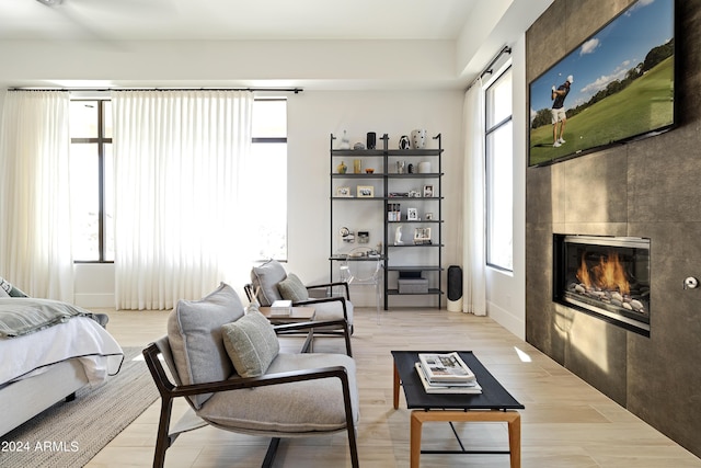 interior space with light wood-style floors and a tiled fireplace