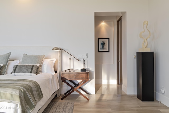 bedroom featuring baseboards and wood finished floors