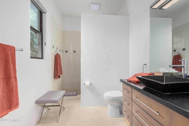 bathroom featuring toilet, walk in shower, vanity, and tile patterned flooring