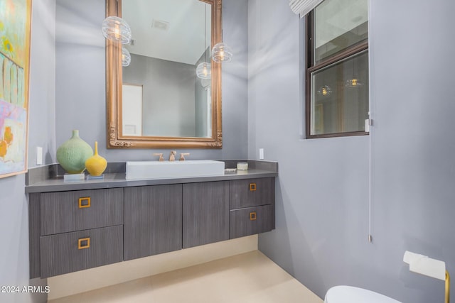 half bathroom with vanity, toilet, and visible vents