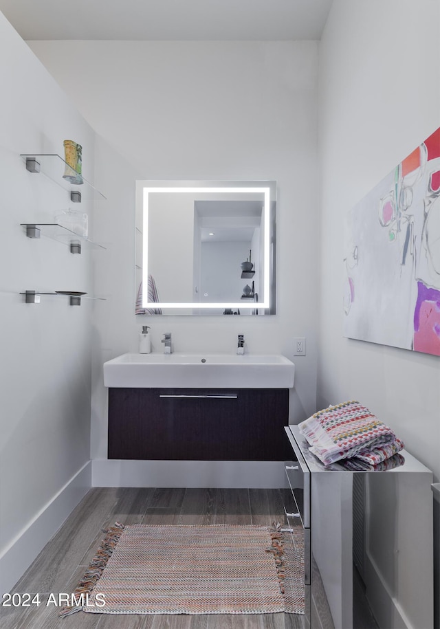 bathroom with vanity, baseboards, and wood finished floors