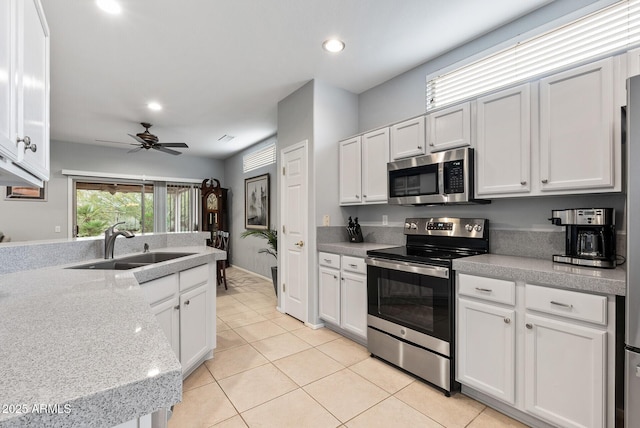20450 N Shadow Mountain Dr, Surprise, AZ 85374 - kitchen with appliances with stainless steel finishes, a sink, light tile patterned flooring, a ceiling fan, and light countertops