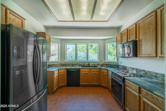 1226 E Greenway Cir, Mesa, AZ 85203 - kitchen featuring black appliances, brown cabinets, dark tile patterned floors, a sink, and dark stone countertops