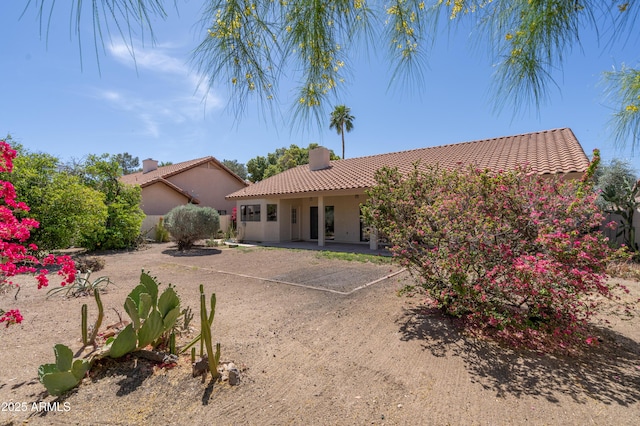 1226 E Greenway Cir, Mesa, AZ 85203 - view of front of house with a tiled roof, a patio area, stucco siding, and a chimney
