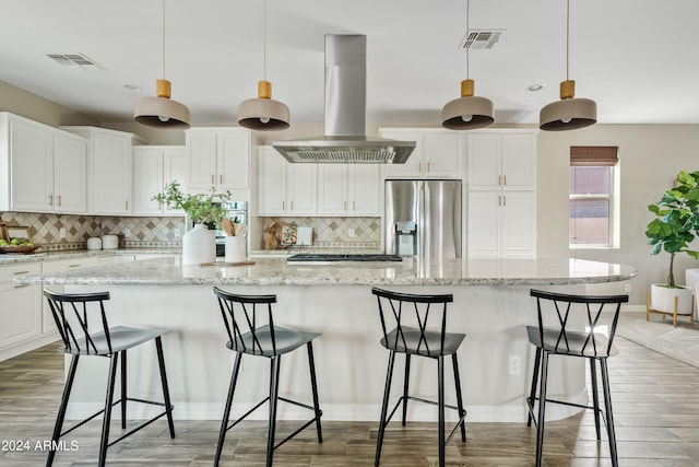 kitchen featuring a spacious island, island exhaust hood, decorative light fixtures, and stainless steel appliances