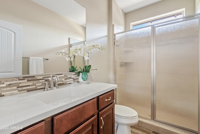 bathroom with toilet, wood-type flooring, backsplash, vanity, and an enclosed shower