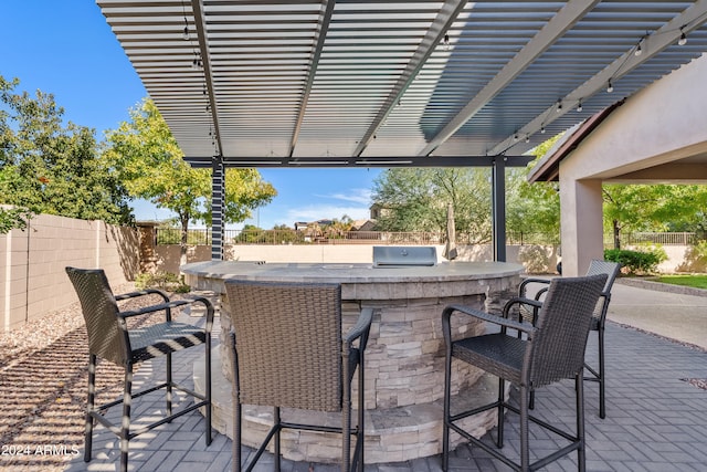 view of patio / terrace featuring a bar, exterior kitchen, and a pergola