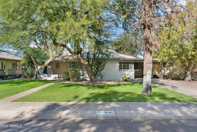 ranch-style home with a front lawn