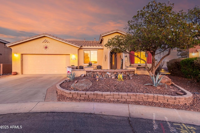 view of front facade featuring concrete driveway, a tiled roof, an attached garage, and stucco siding