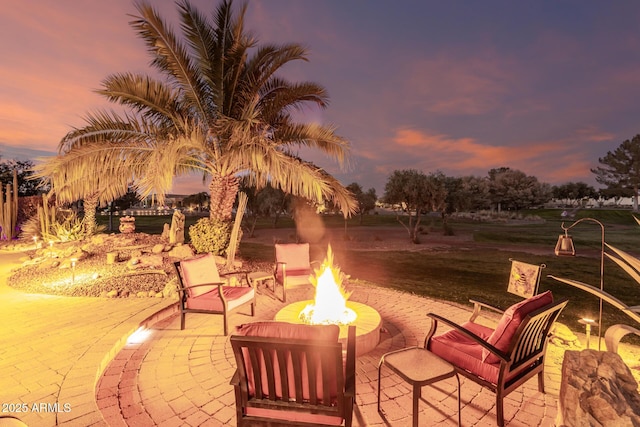 patio terrace at dusk featuring a fire pit