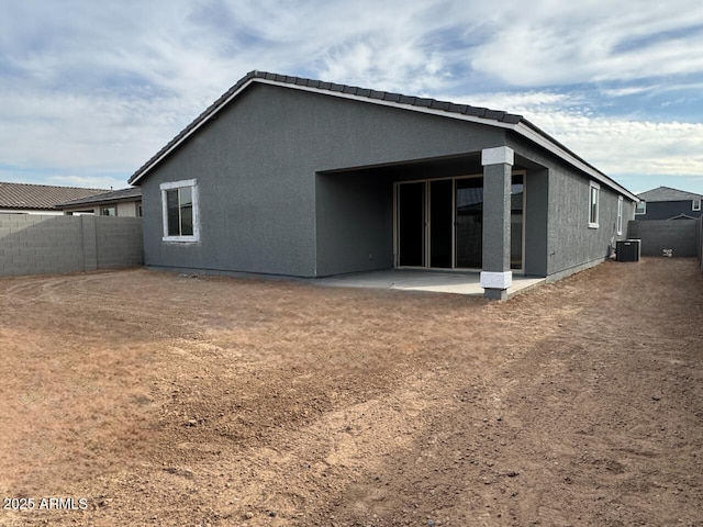 rear view of property with central AC unit and a patio