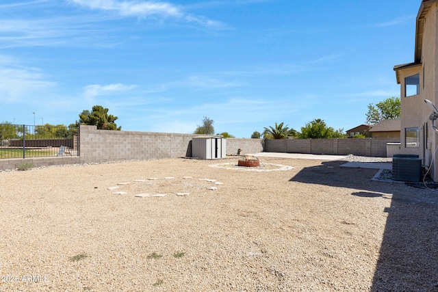 1612 E Desert Rose Trl, San Tan Valley, AZ 85143 - view of yard featuring central AC, a fenced backyard, and an outdoor fire pit