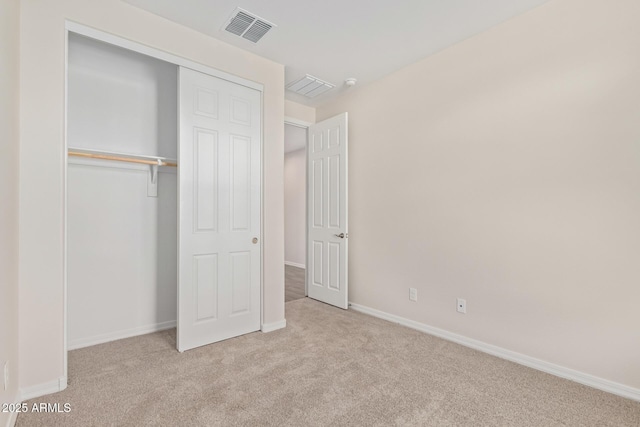 unfurnished bedroom with light carpet and a closet